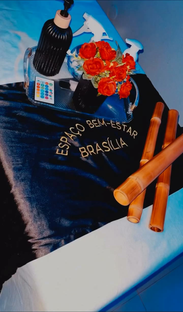 Bambus de massagem, rosas e óleo sobre a faixa bordada da maca