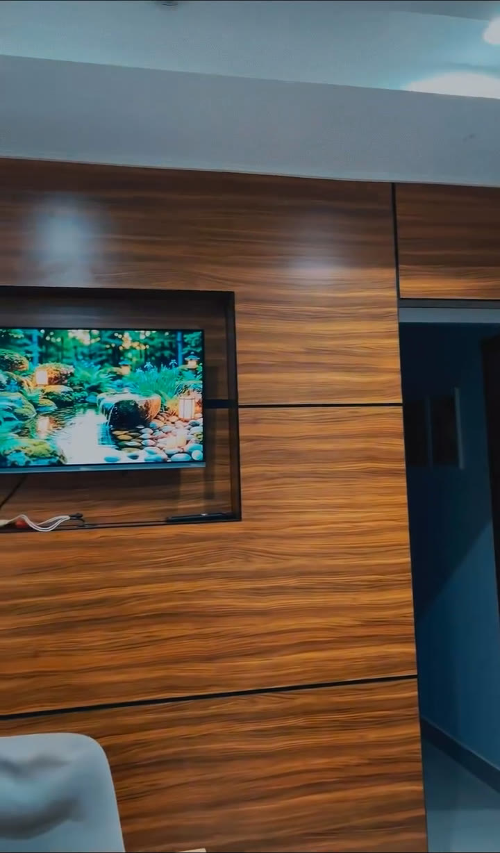Recepção do Espaço Bem-Estar, com painel de madeira e TV exibindo uma paisagem de natureza